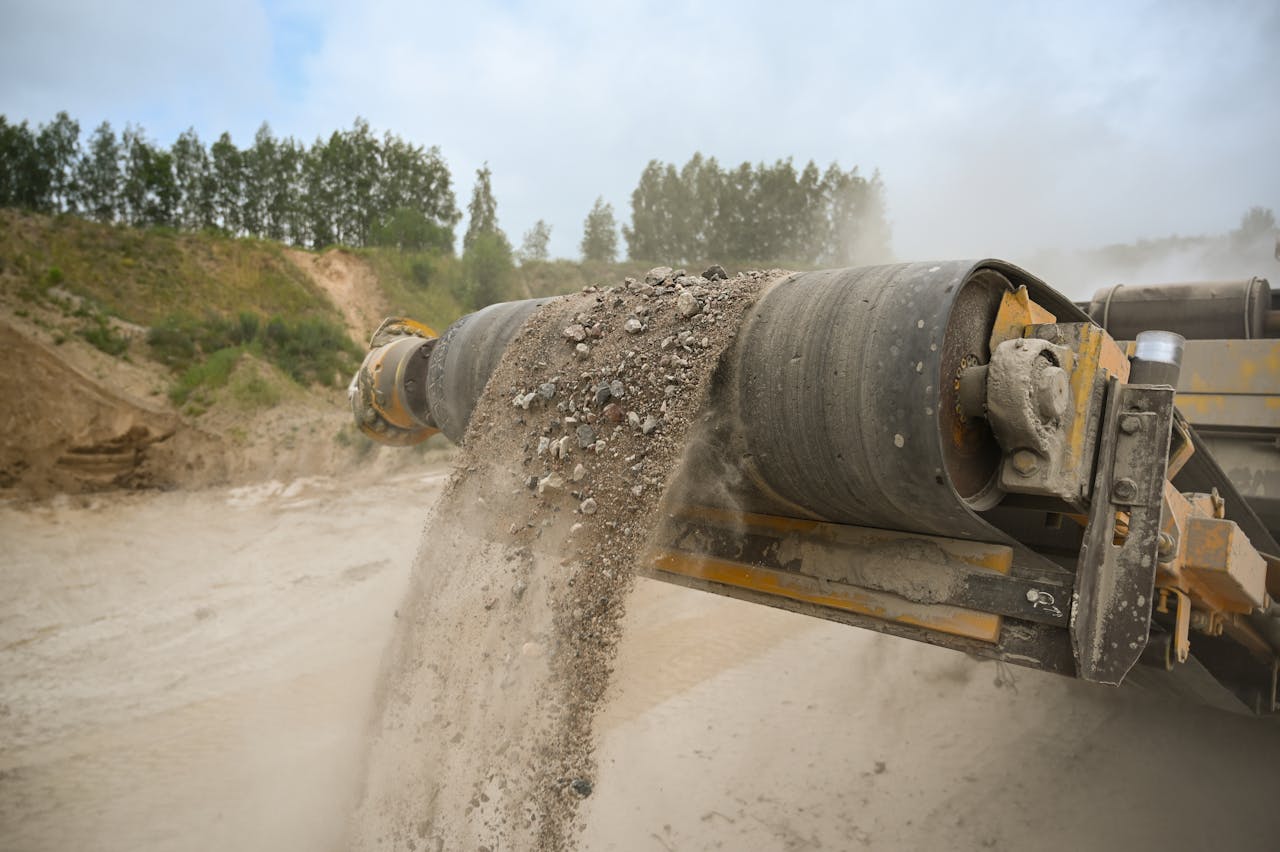 our-journey-01 A close-up of an industrial conveyor belt moving gravel at a construction site