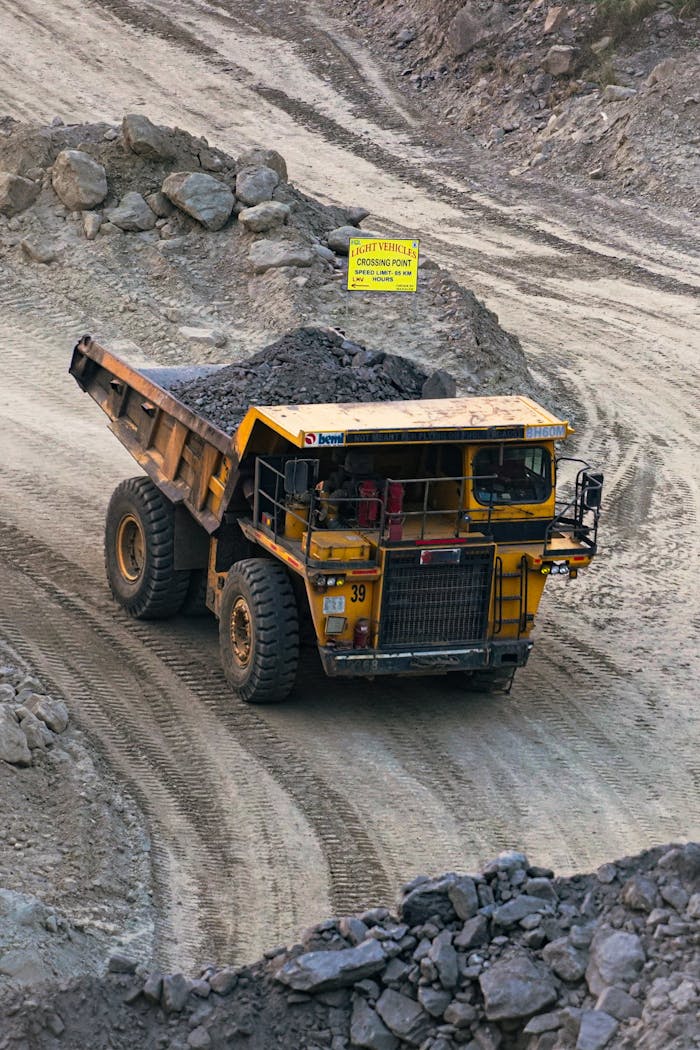 our-journey-03 Heavy mining truck transporting minerals in a rocky open-pit quarry in Bahula, West Bengal.
